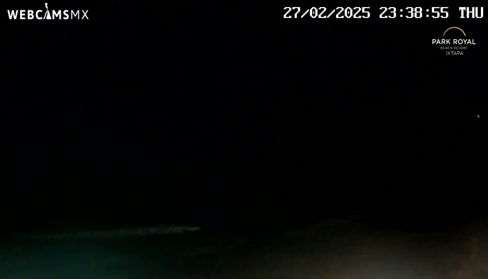 A dark nighttime scene shows a dimly lit body of water at the bottom of the frame under a clear, starlit sky.