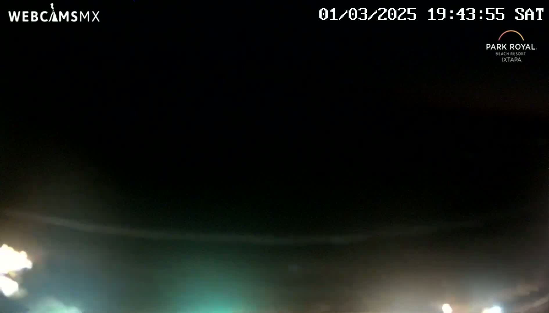 A nighttime long shot shows a dark, mostly clear sky over a dimly lit area with faint lights visible in the bottom corners.