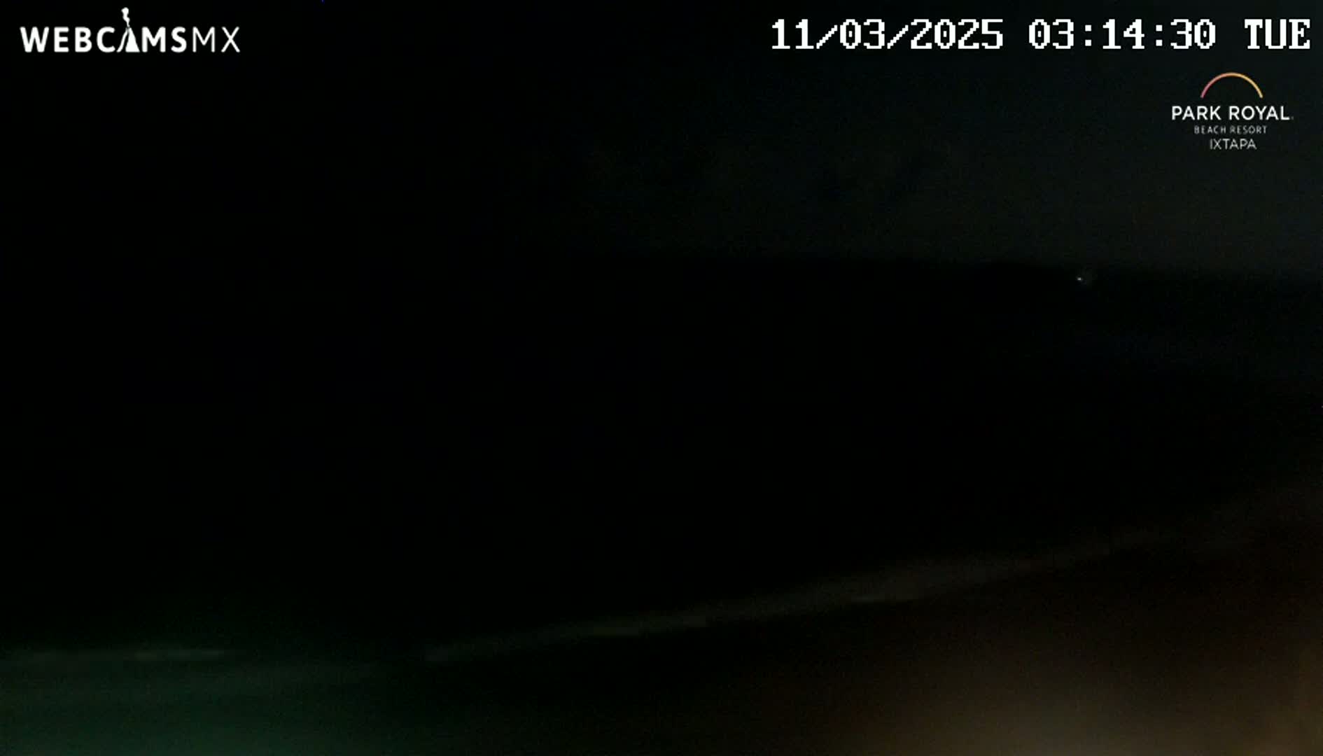A dark nighttime scene shows a mostly black body of water under a dark sky.