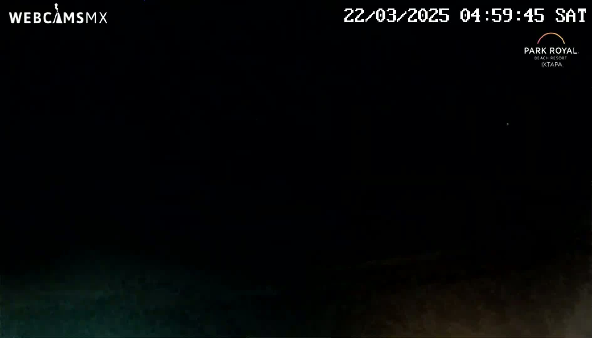 A dark, nighttime scene shows a mostly black ground with a slightly lighter, brownish-gray area at the bottom.