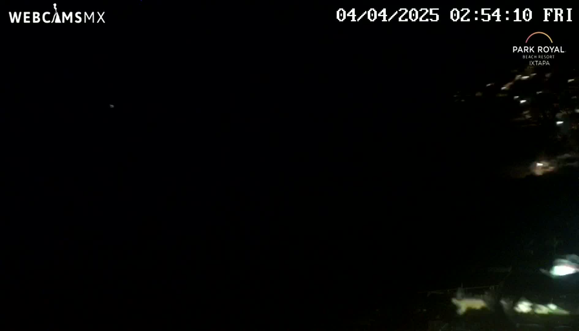A nighttime, dark image shows a few distant lights at the bottom of the frame.