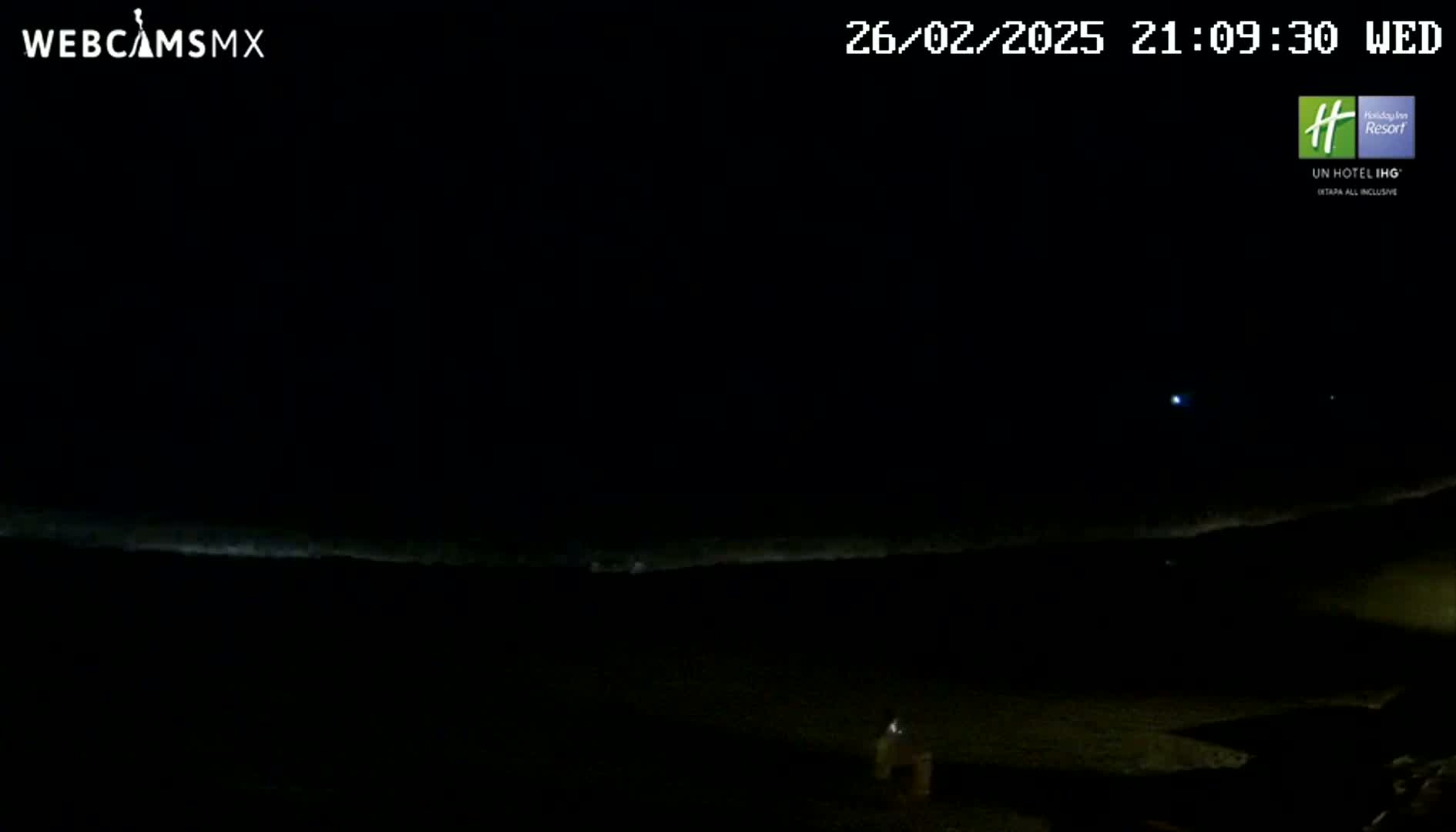 A dark nighttime scene shows a dimly lit ocean horizon under a clear, starlit sky.