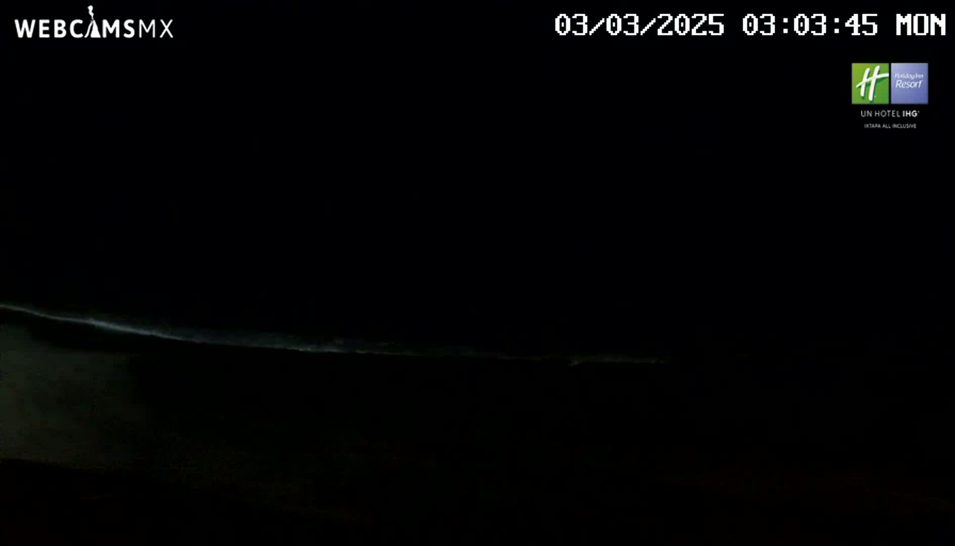A dark, nighttime scene shows a faint, horizontal line of light on the horizon.