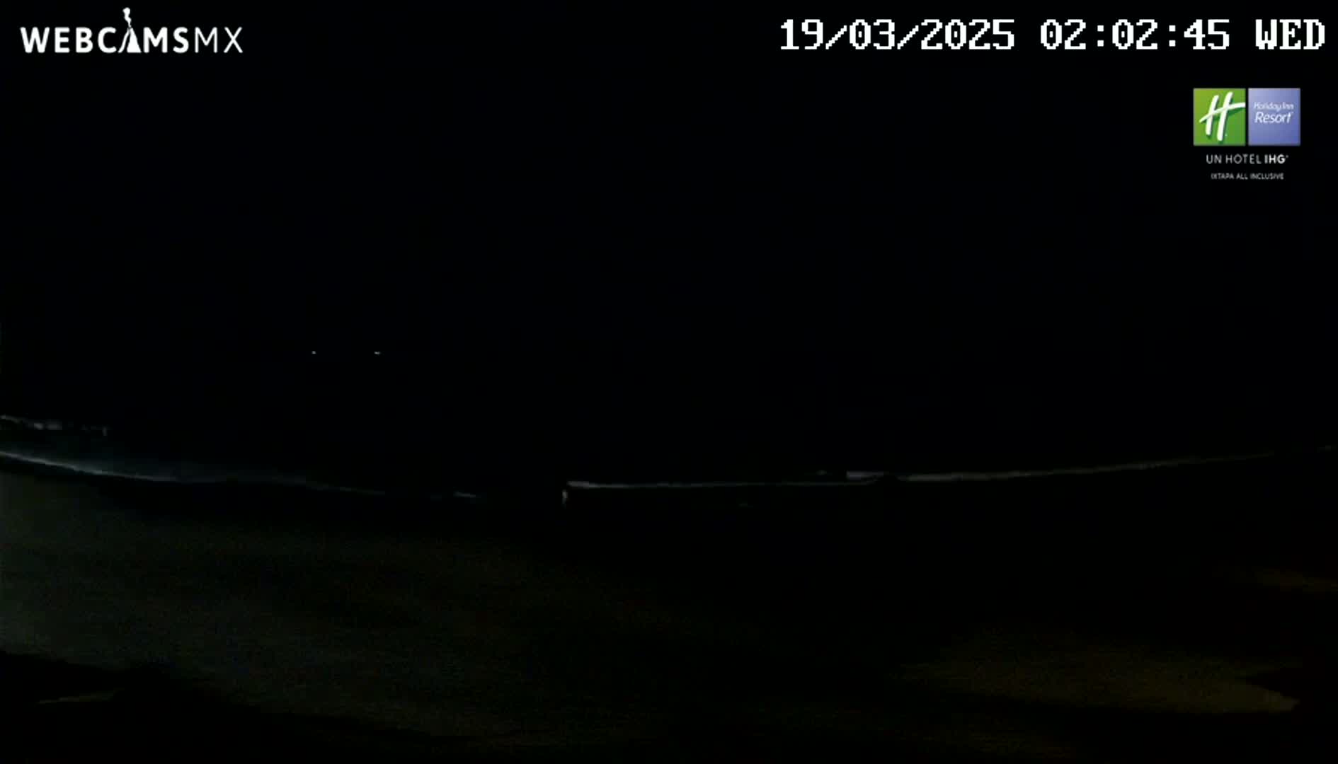 A dark, nighttime scene shows a dimly lit, horizontal line in the distance.