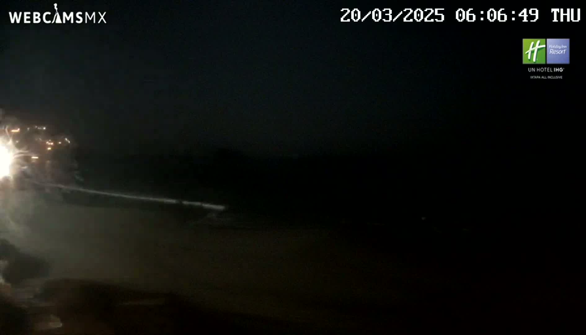 A nighttime fireworks display is seen, with bright sparks illuminating a dark, mostly obscured foreground.