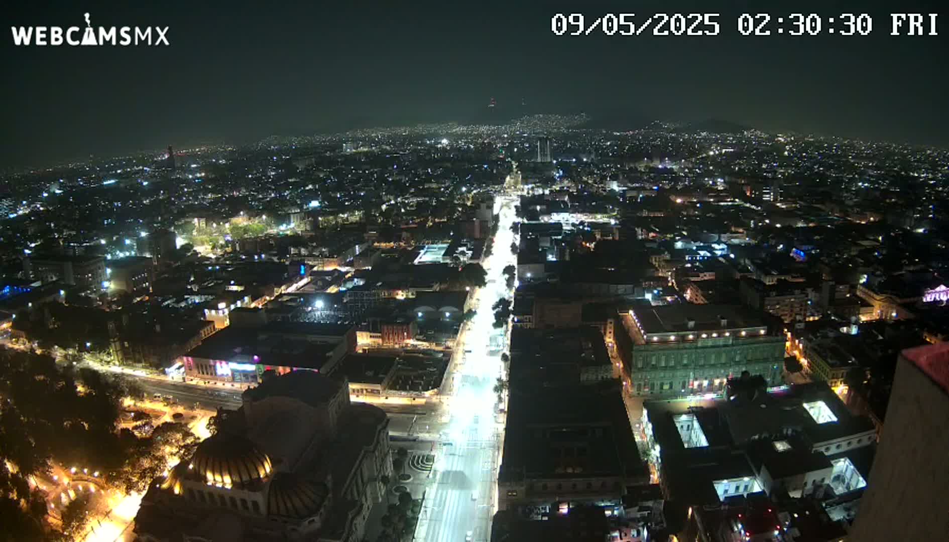 A nighttime, high-angle view shows a sprawling city with brightly lit streets and buildings.