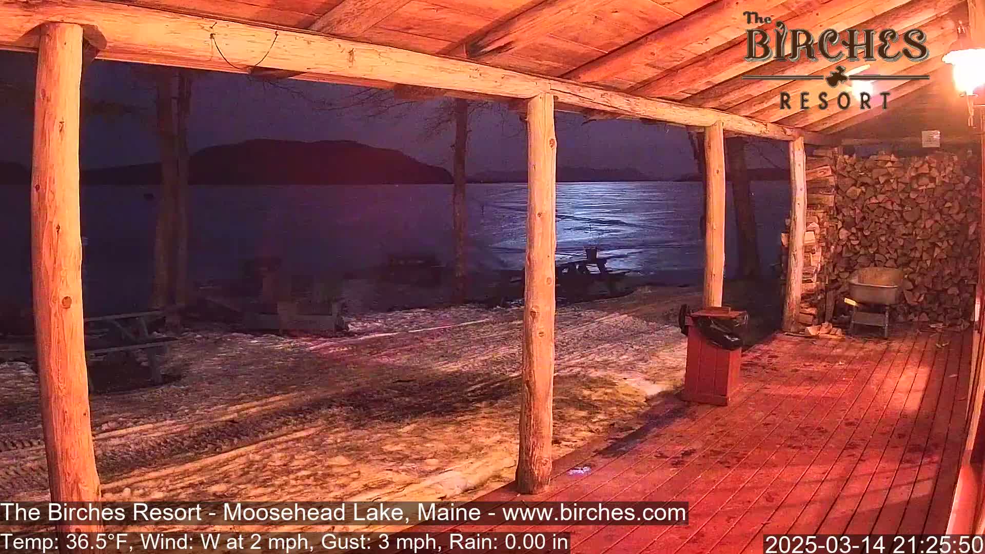 A porch overlooking a moonlit, partially frozen lake at night.