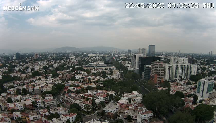 An aerial view of a sprawling city with numerous residential buildings under an overcast sky.