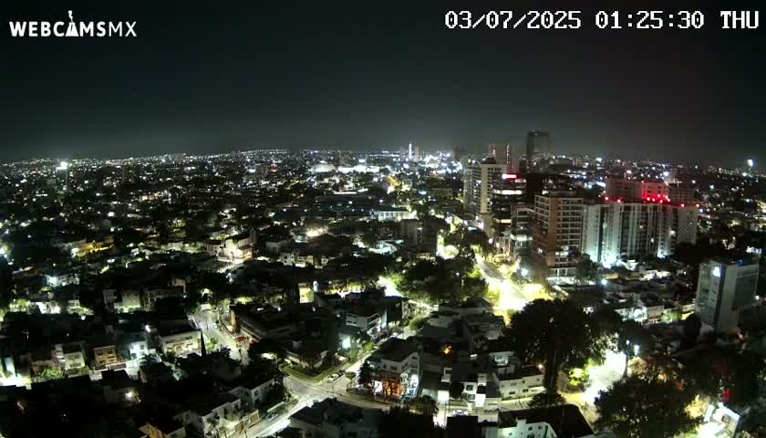 A nighttime aerial view of a city illuminated by streetlights and building lights.
