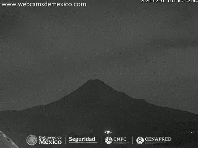 A dark, silhouetted volcano is visible under a twilight sky.