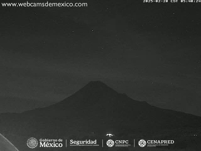 A dark, mountainous landscape is visible under a night sky with a few stars.