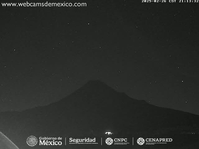 A dark, starlit night sky is visible above a silhouetted mountain range.