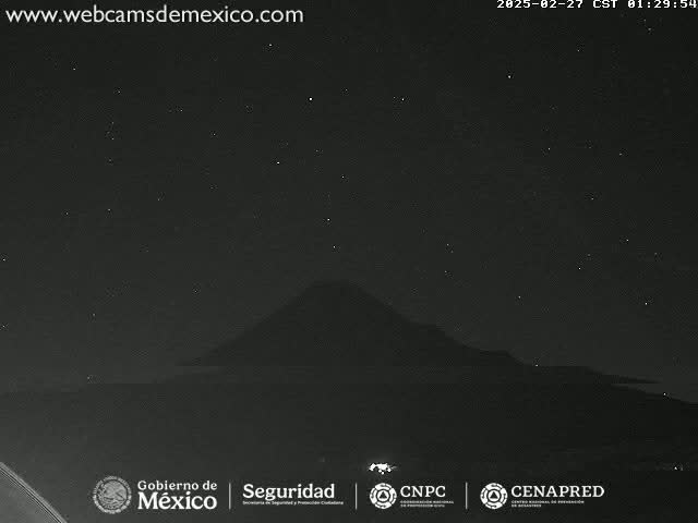 A dark, star-filled night sky is visible above a silhouetted mountain range.