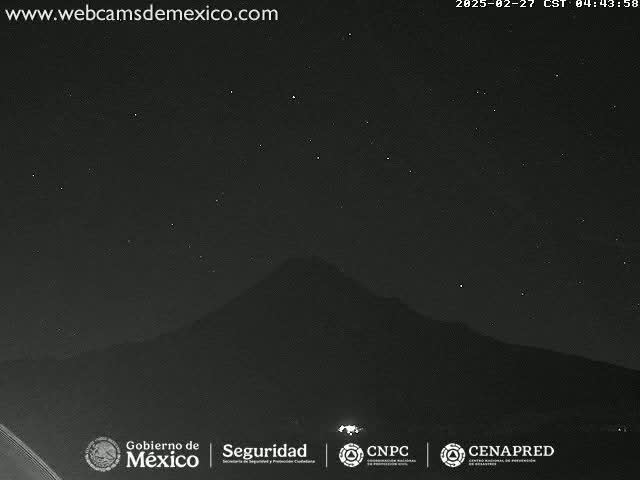 A dark, nighttime image shows a mountain silhouetted against a starry sky.