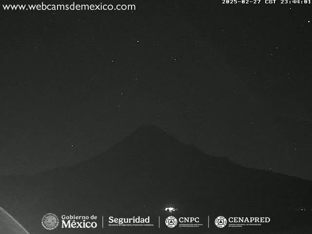 A dark, starlit night sky shows a silhouetted mountain.