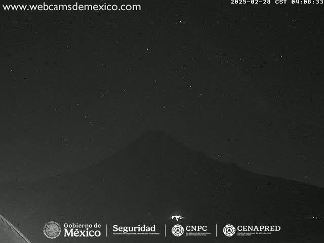 A dark, clear night sky shows a mountain silhouette against a backdrop of visible stars.