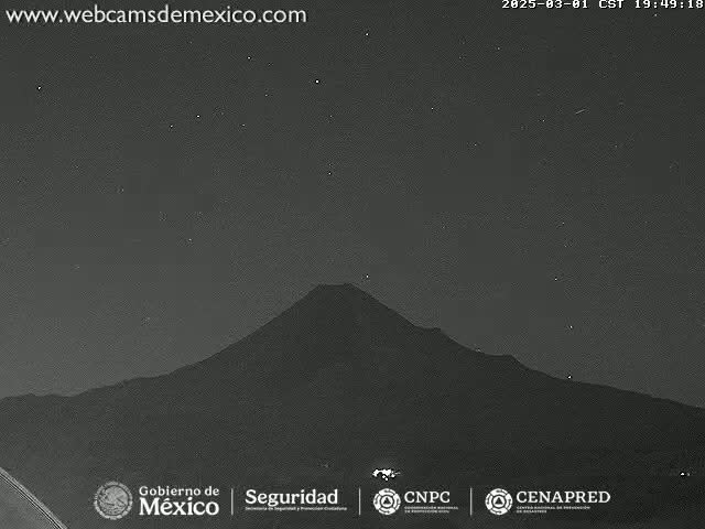 A dark, mountainous landscape is visible under a clear, starry night sky.