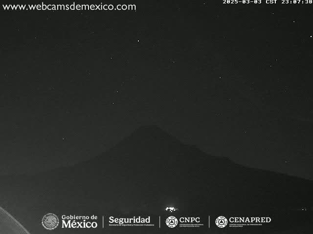A dark, starlit night sky is visible above a silhouetted mountain range.