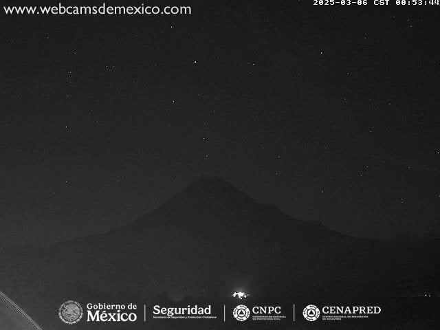 A dark, starlit night scene shows a mountain silhouette against a mostly clear sky.