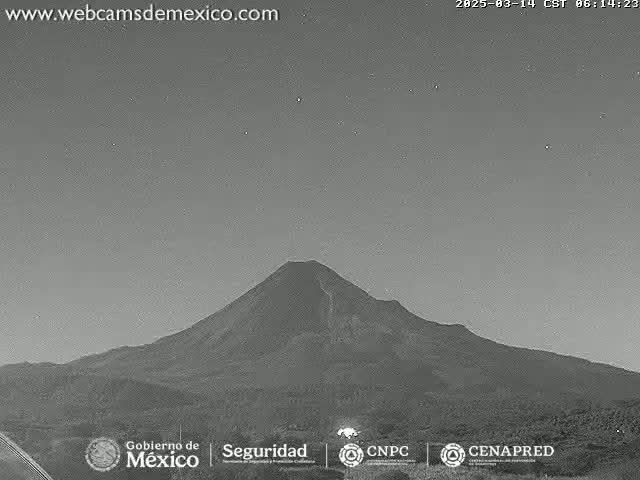 A large, dark volcano is visible under a twilight sky.