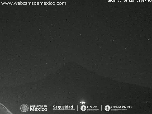 A nighttime, long shot shows a dark mountain silhouetted against a clear, starry sky.