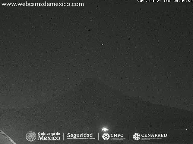 A dark, night-time view of a mountain silhouette under a clear, starry sky.