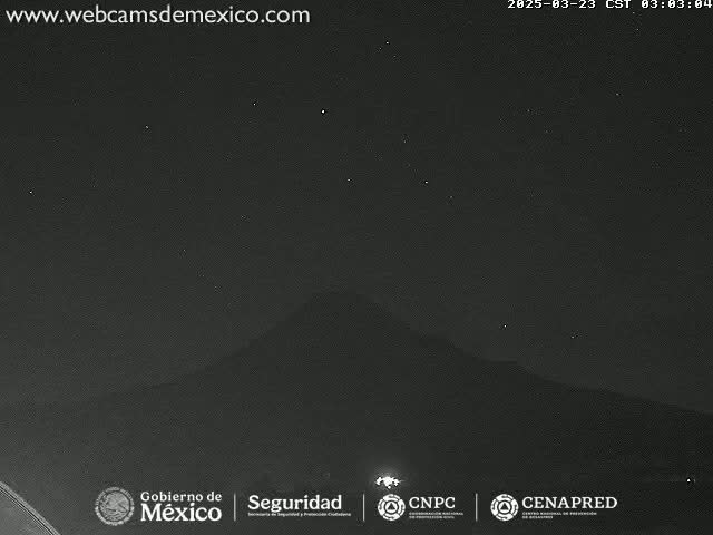 A nighttime, clear-sky view shows a dark mountain silhouetted against a star-filled sky.