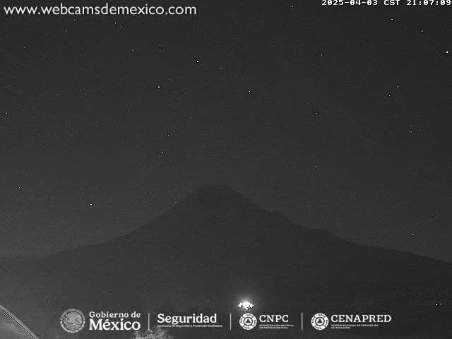 A dark, clear night shows a mountain silhouetted against a starry sky.