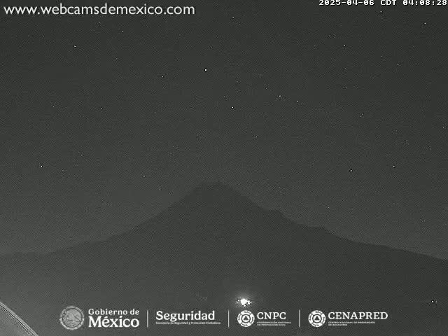 A dark, nighttime image shows a mountain silhouetted against a starry sky.