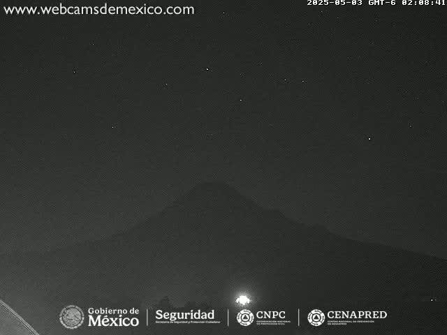 A dark, nighttime scene shows a distant, silhouetted mountain under a clear, starlit sky.