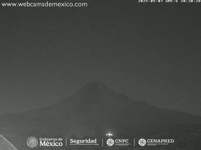 A dark, nighttime view of a mountain silhouette under a clear, starry sky.