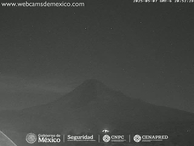 A dark, night-time view of a large, distant mountain under a clear, starry sky.