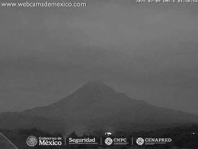 A hazy, overcast sky covers a dark, mountainous landscape.