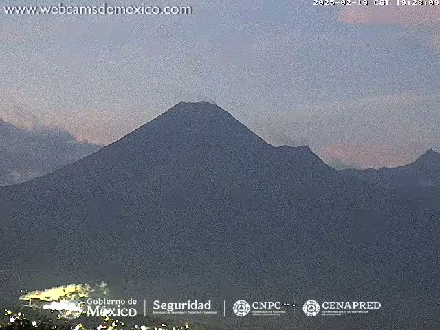 A large, dark mountain range is visible under a dusky, twilight sky.