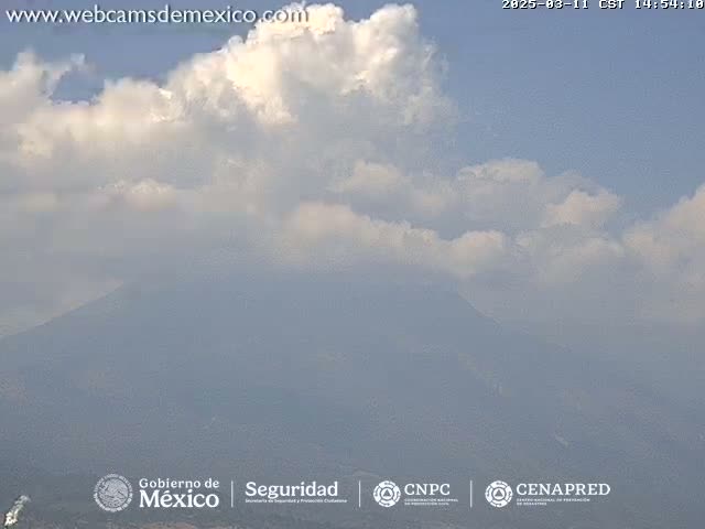 A partly cloudy sky overlooks a hazy, distant mountain range.
