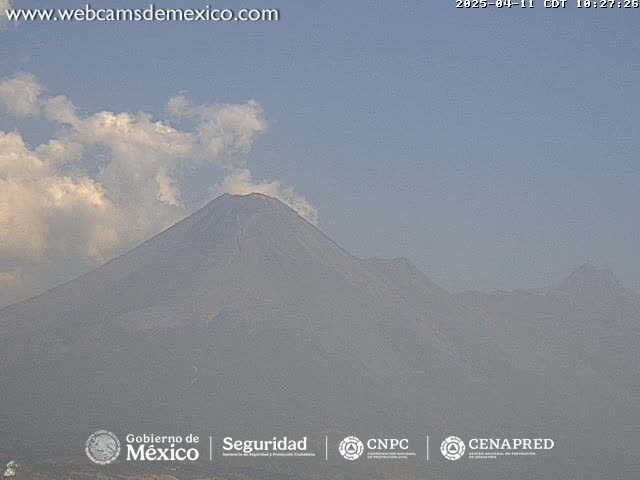 A hazy mountain range is visible under a partly cloudy sky.