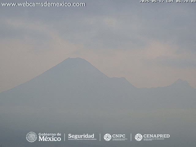 A hazy, light-grey mountain range is visible under a cloudy sky.