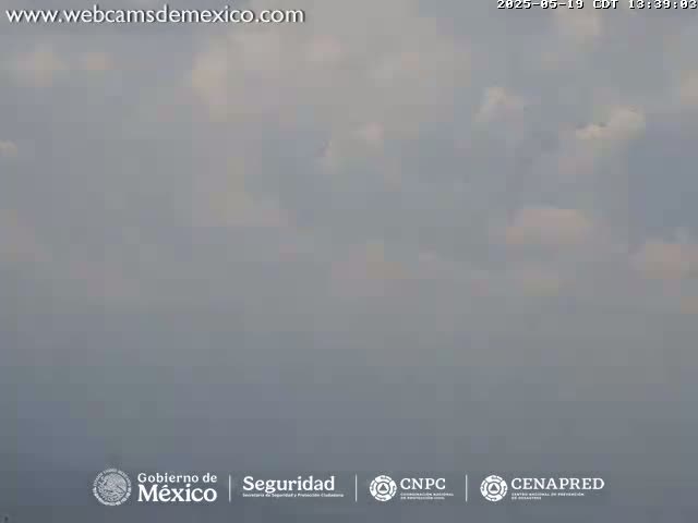 A hazy, overcast sky with scattered clouds is visible.