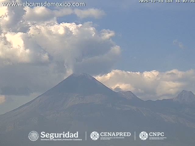 A grainy, monochromatic image captured at night shows a bright, glowing light source emerging from the bottom against a heavily overcast or hazy sky.