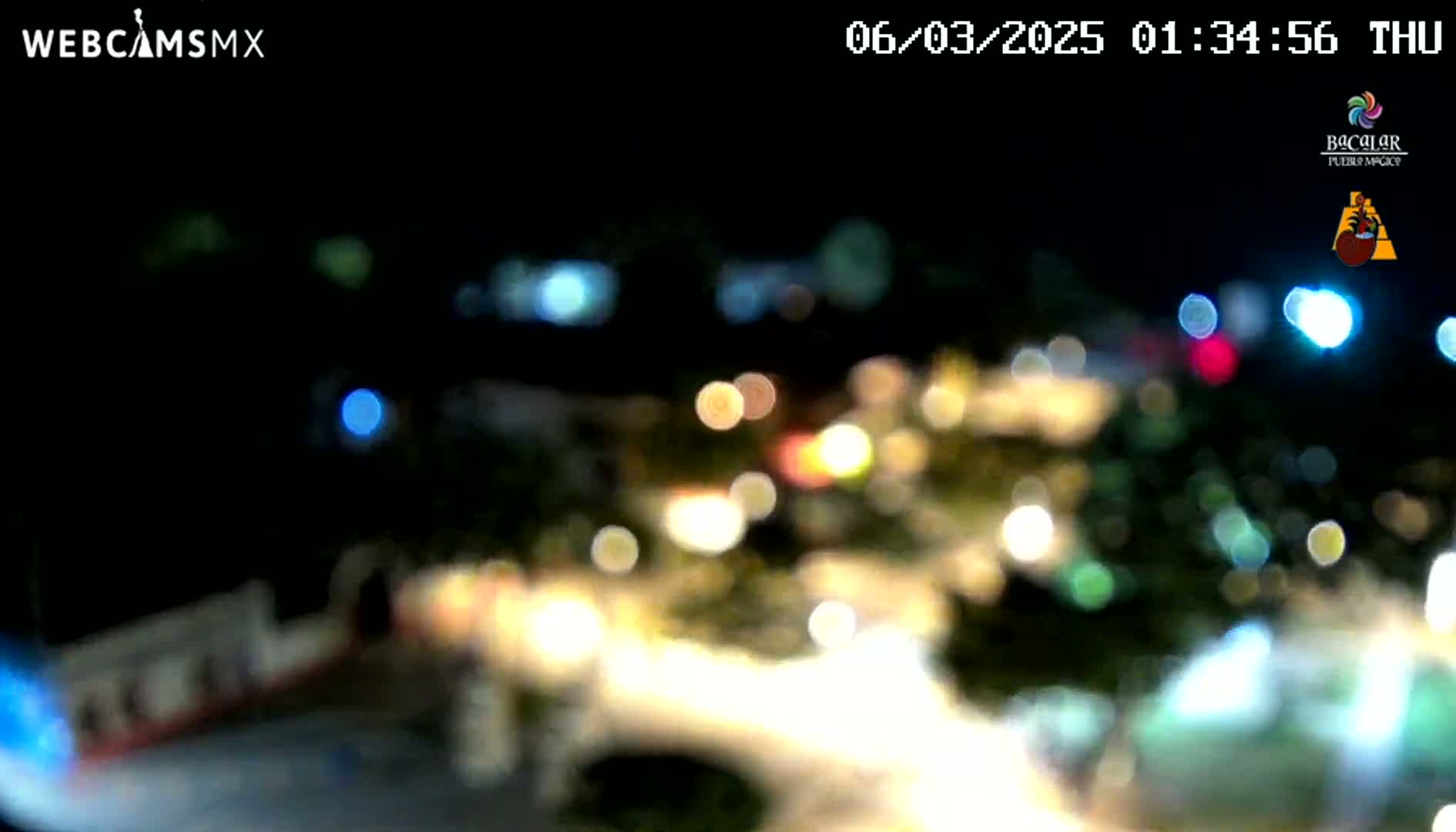 A blurry, nighttime view of multicolored lights from a distance.