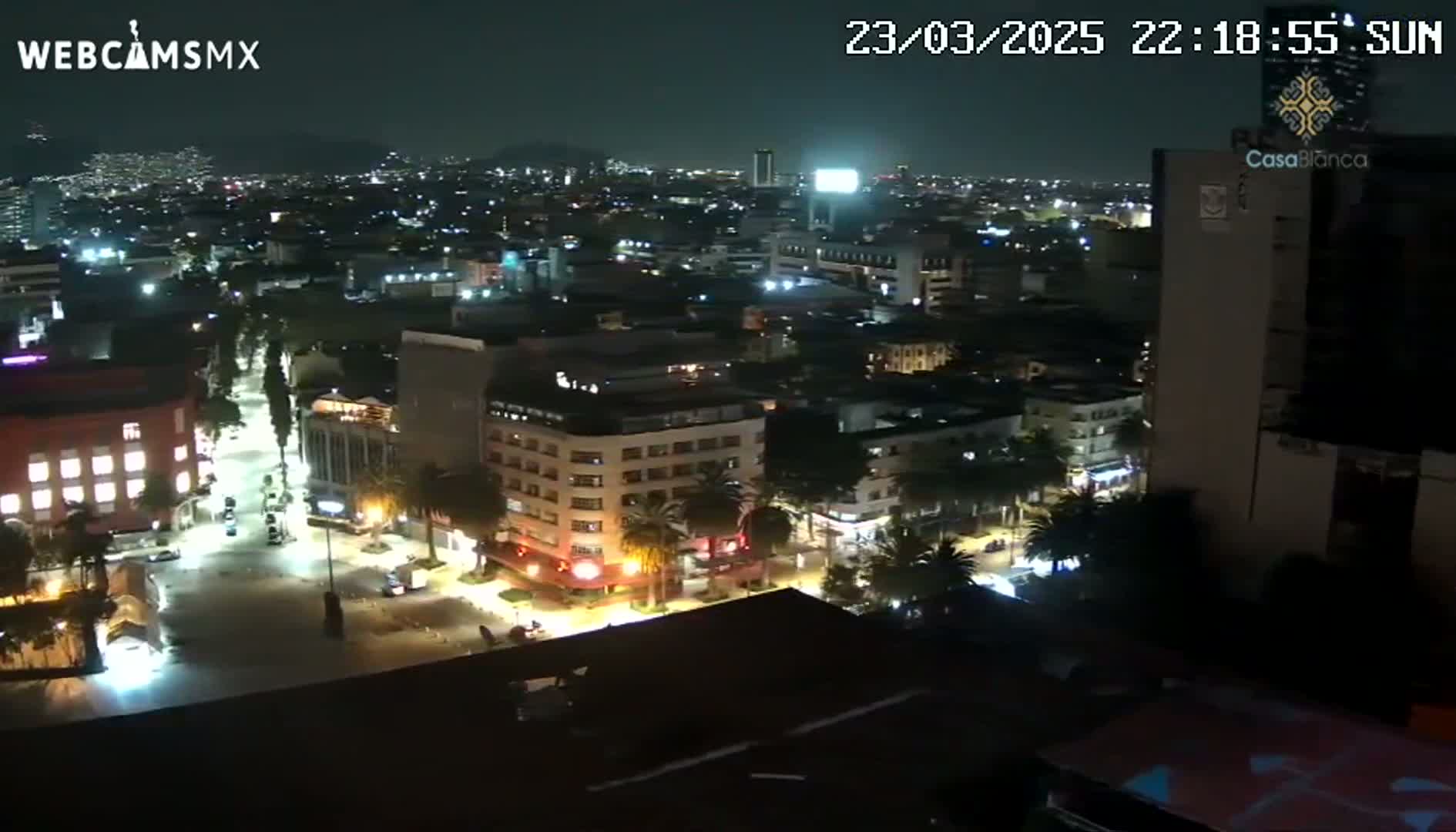 A nighttime, high-angle view of a city with illuminated streets and buildings.