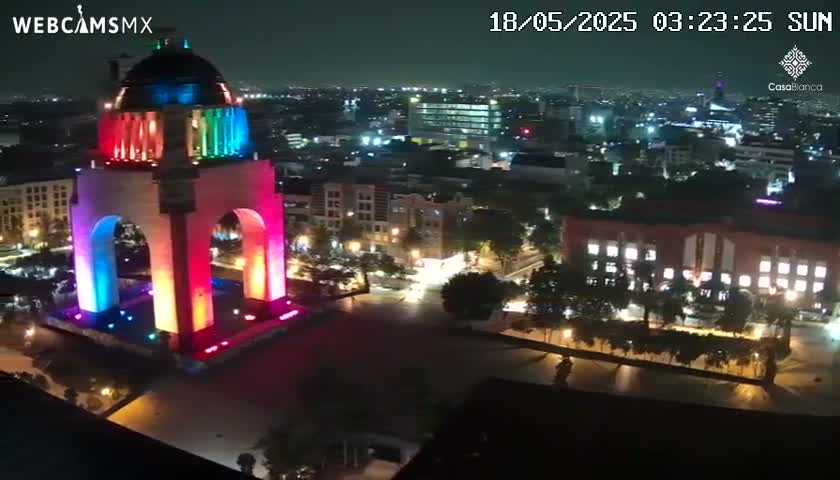A brightly lit monument stands in a city at night.