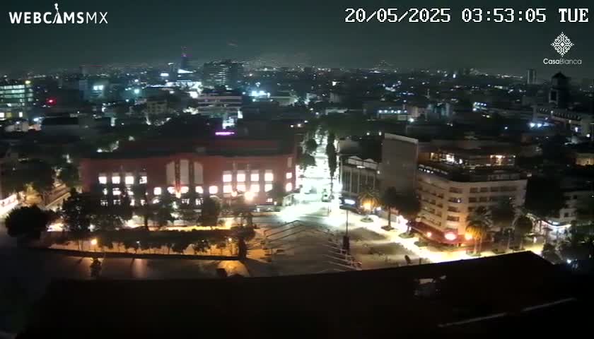 A nighttime, high-angle view of a city illuminated by streetlights and building lights.