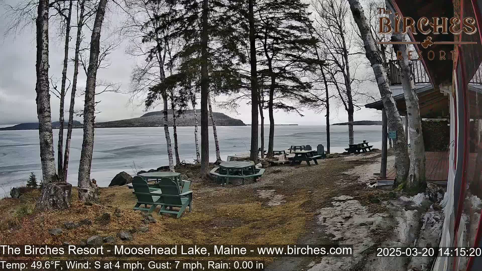 A partly frozen lake is seen from a lakeside resort on an overcast day with a south wind.