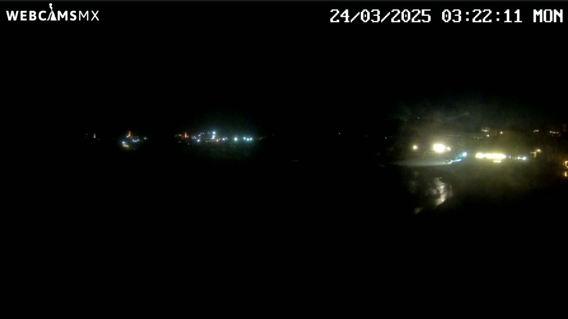 A nighttime long shot shows a dark landscape with a few distant lights visible.