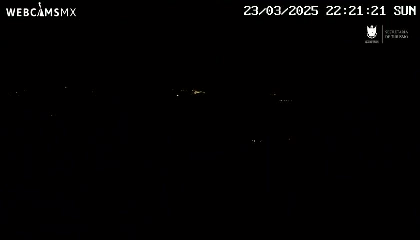 A nighttime long shot shows a few distant lights in the dark.