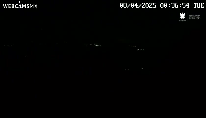 A nighttime long shot shows a dark landscape with sparsely scattered faint lights in the distance.