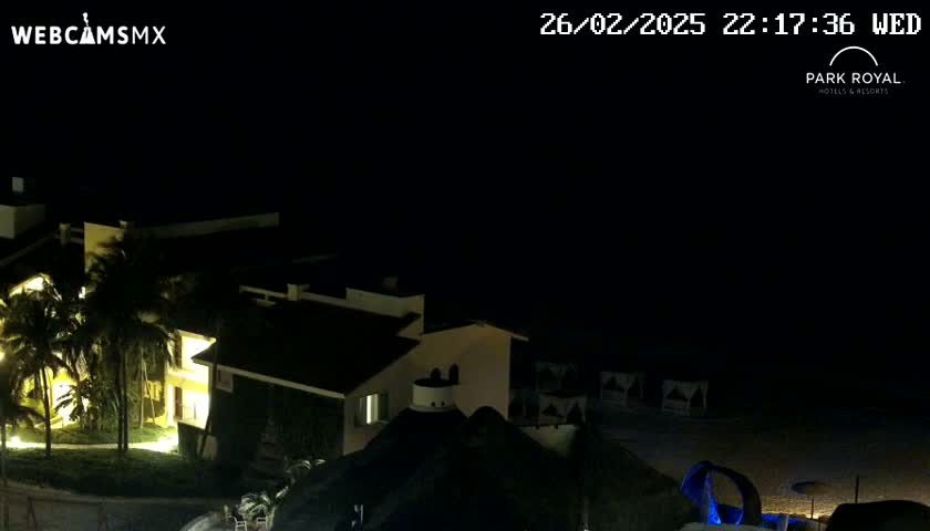 A nighttime view of a resort complex illuminated by exterior lights, under a clear, dark sky.