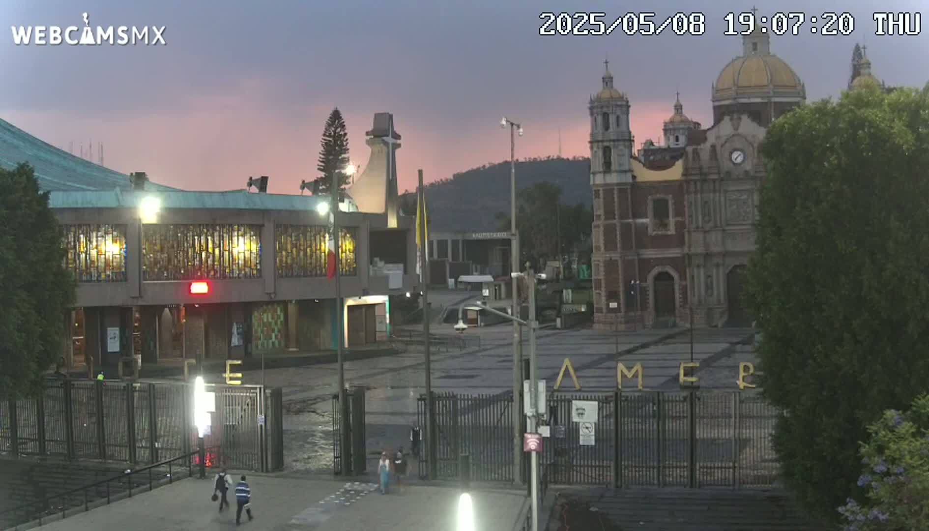 A large basilica complex is visible at dusk under a pinkish-purple sky.