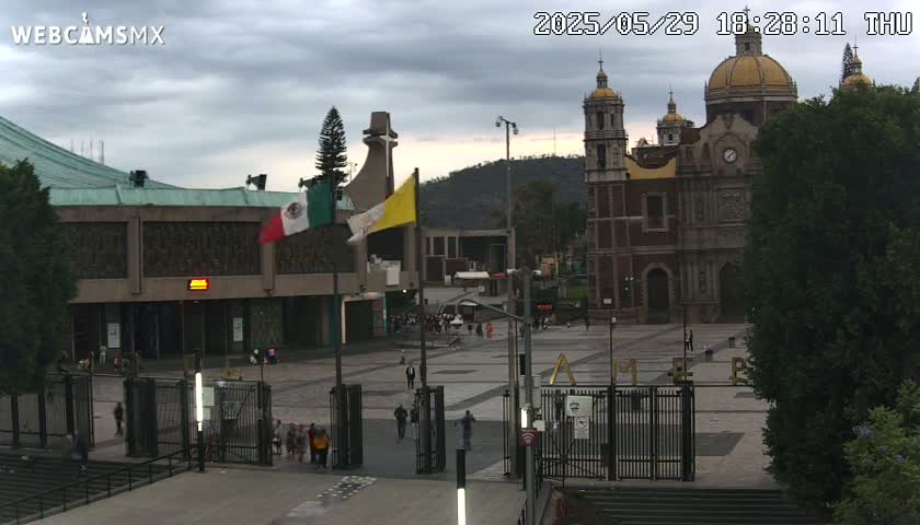 A large plaza with a basilica and other buildings under an overcast sky.